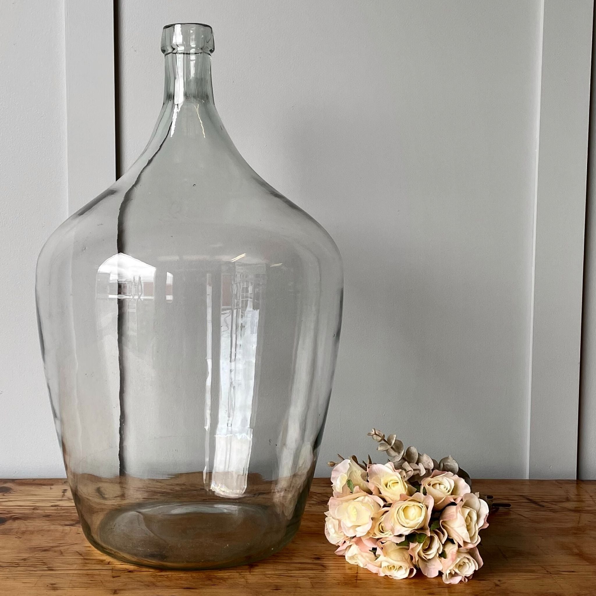 A very large vintage clear glass carboy