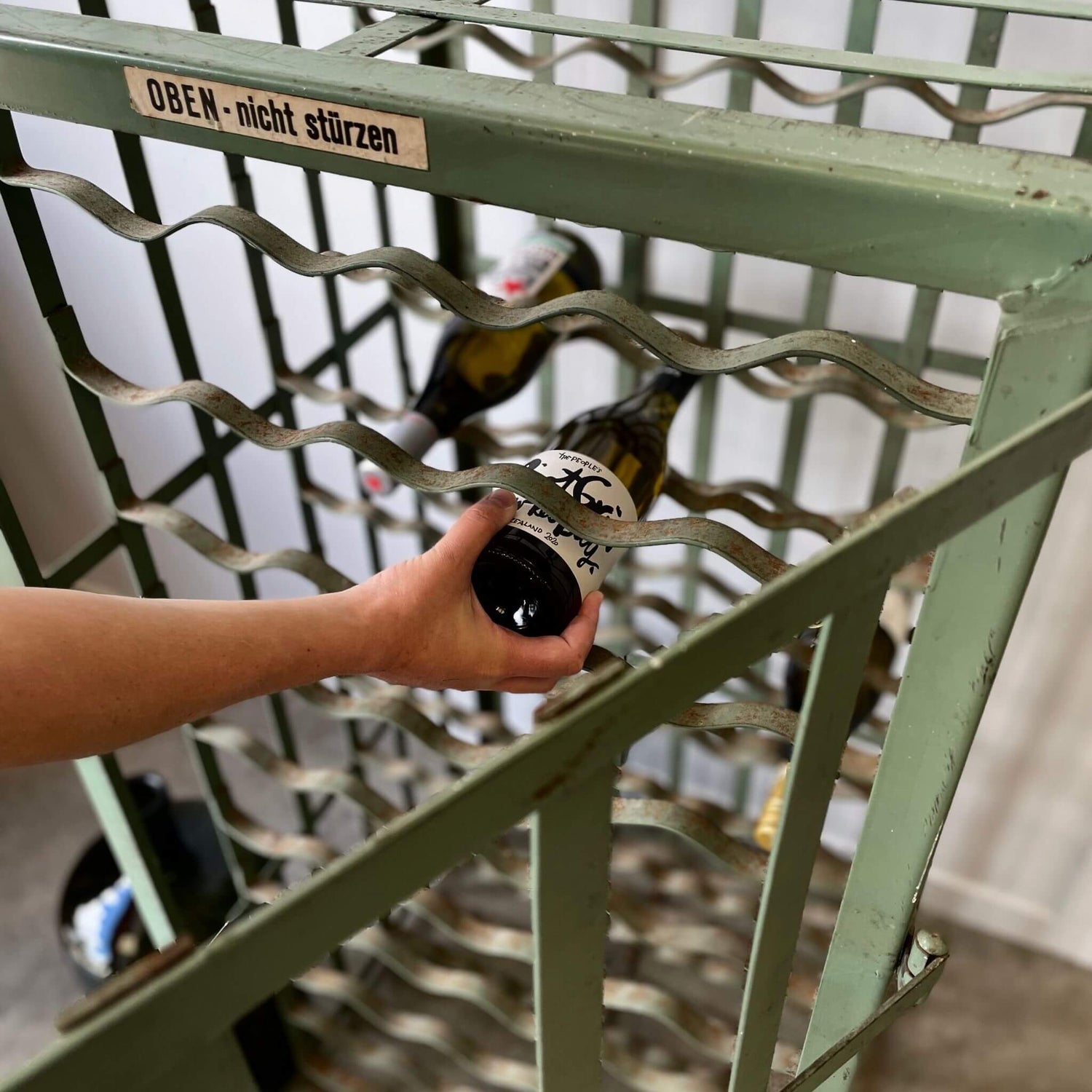 A bottle of wine coming out of a cabinet